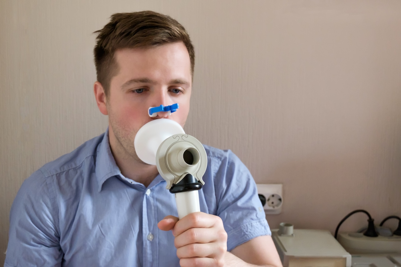 Young man testing breathing function